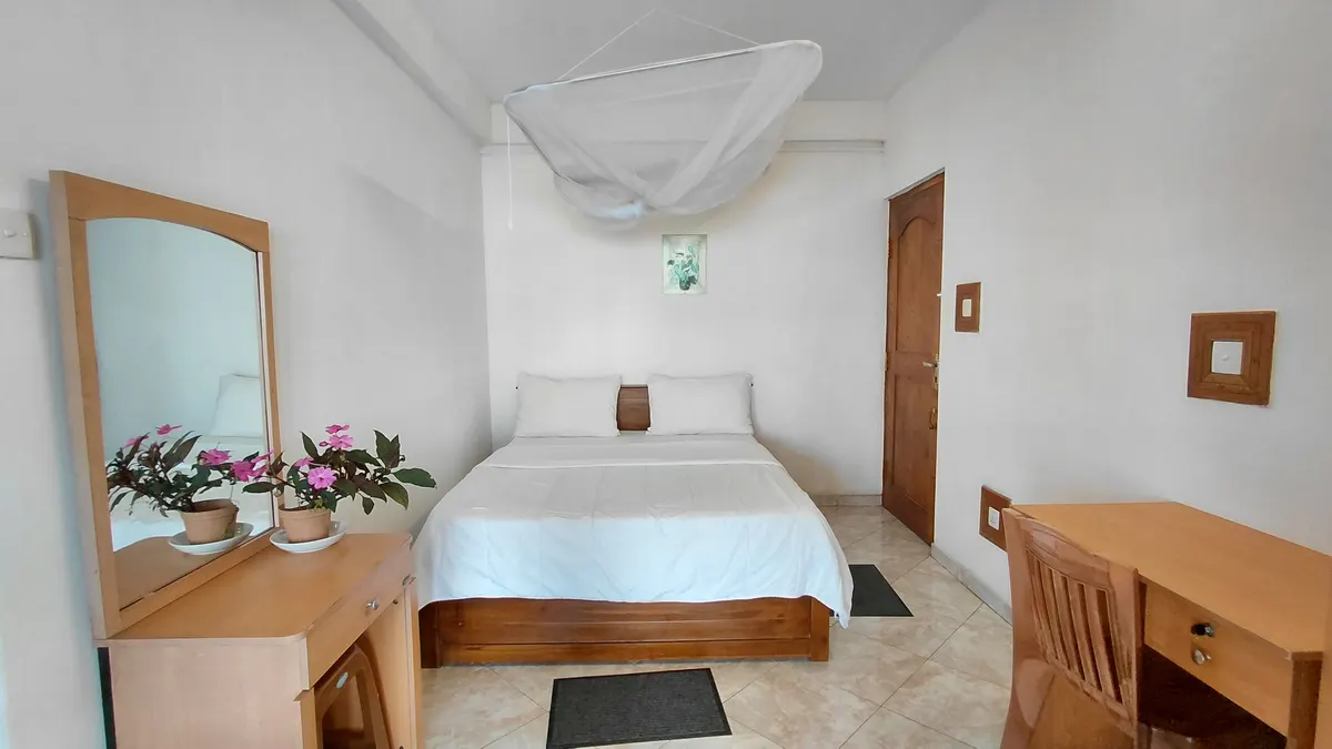 Super Deluxe Double Room at The Mist with a double bed and wood furniture.