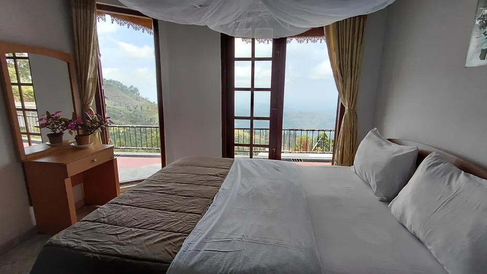 Bed and doors opening to the balcony in Super Deluxe Family Room 106.