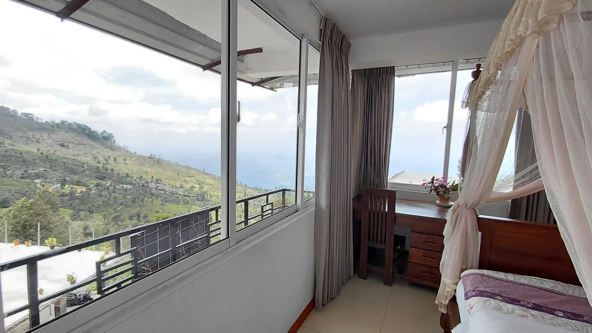 Superior Double Room at The Mist with a bed beside windows and balcony doors.