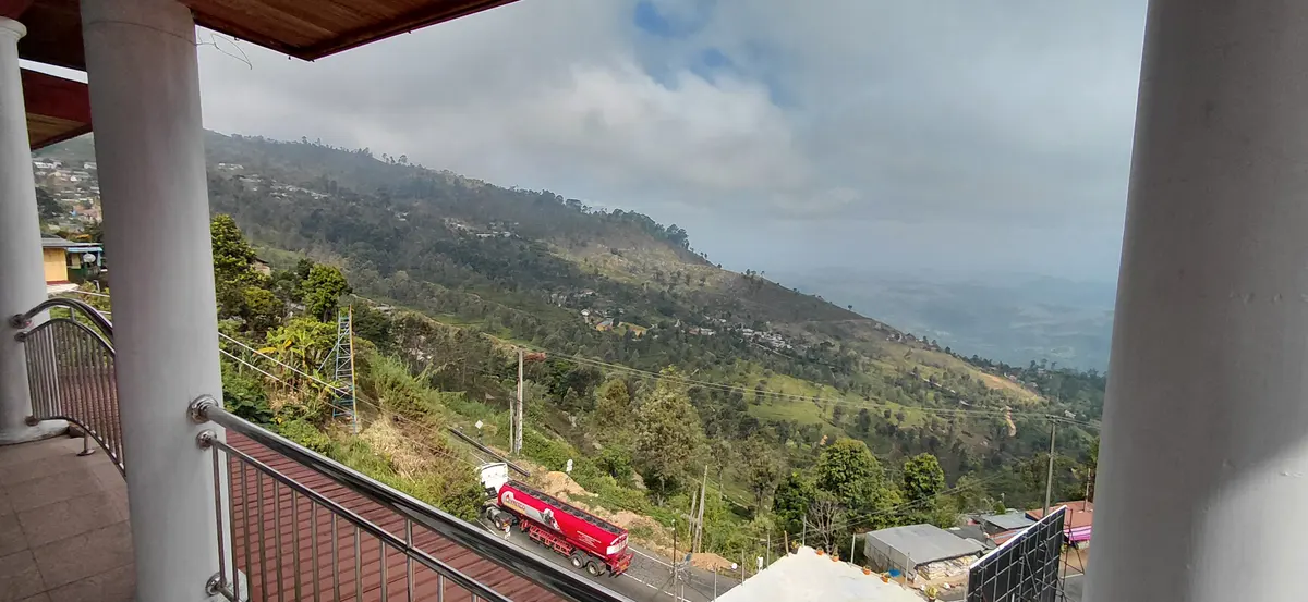 View towards green hills from a covered balcony.