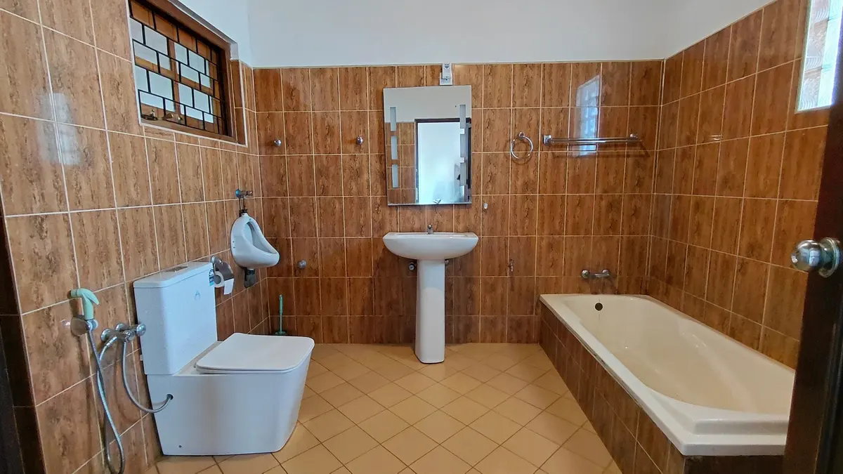 Tiled bathroom with a basin, bathtub and shower.