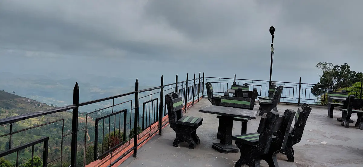 Outdoor terrace seating with hills in the distance.