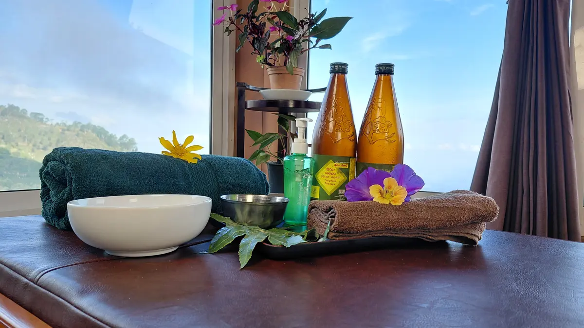 Towels, bowls and flowers arranged on a treatment table.