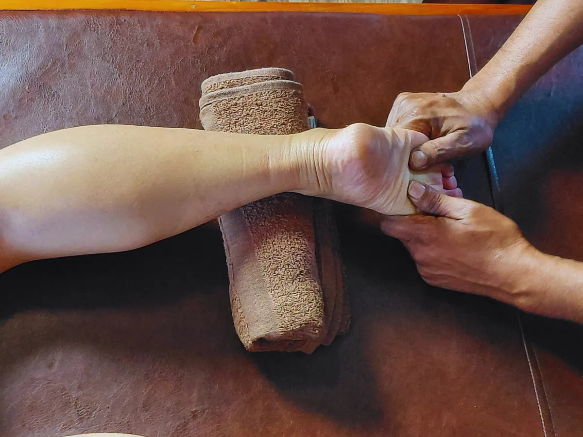Hands massaging a guest's foot.