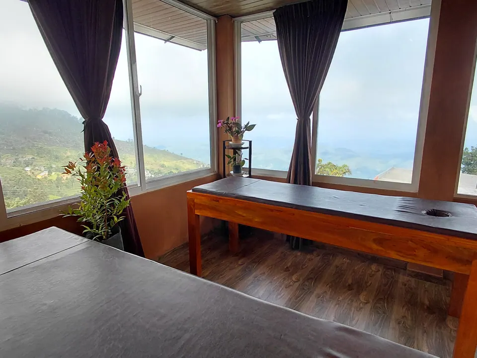 Two empty treatment tables beside wide windows.